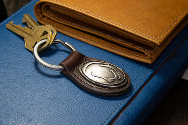 Penn State Oval Leather Key Fob. Sturdy Split Ring and Durable Stitching. Perfect Collegiate Key Chain Gift. Brown or Black Leather.