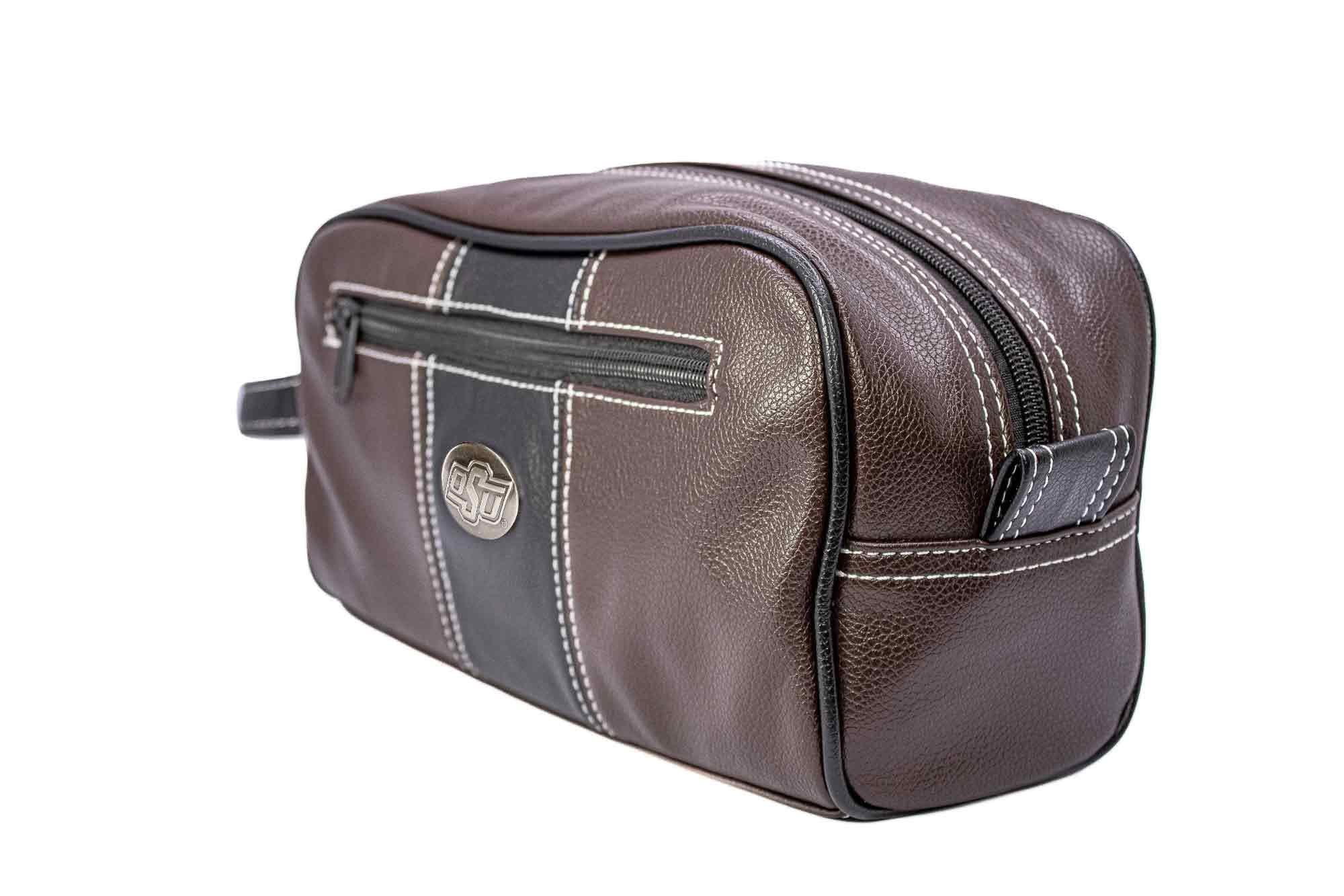 Oklahoma State Cowboys Men's Toiletry Dopp Bag. Brown Pebble PU Finish. OSU Silver Logo. Durable Water Resistant. Spacious Design.