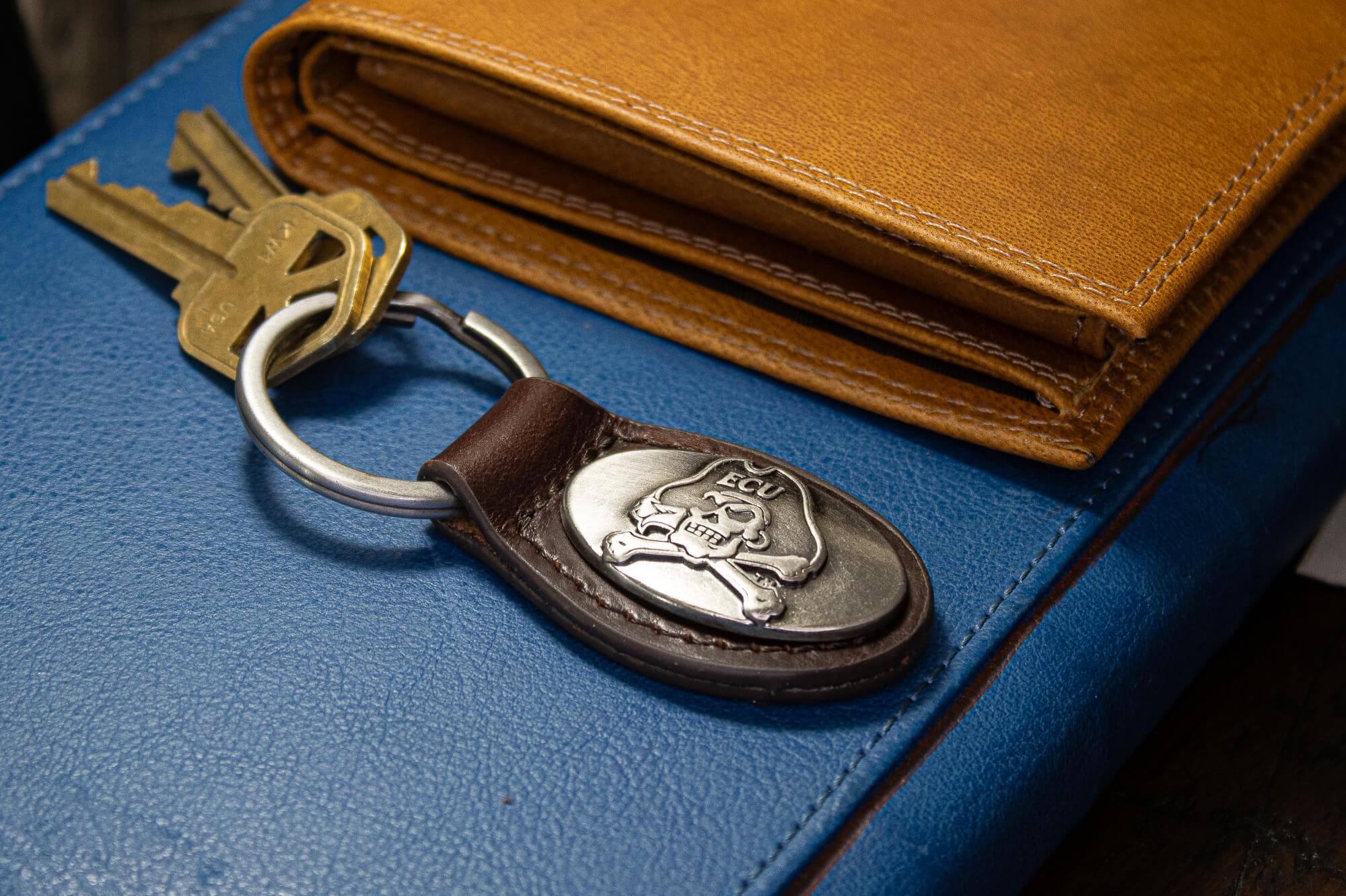 ECU Pirates Oval Leather Key Fob. Sturdy Split Ring and Durable Stitching. Perfect Collegiate Key Chain Gift. Brown or Black Leather.