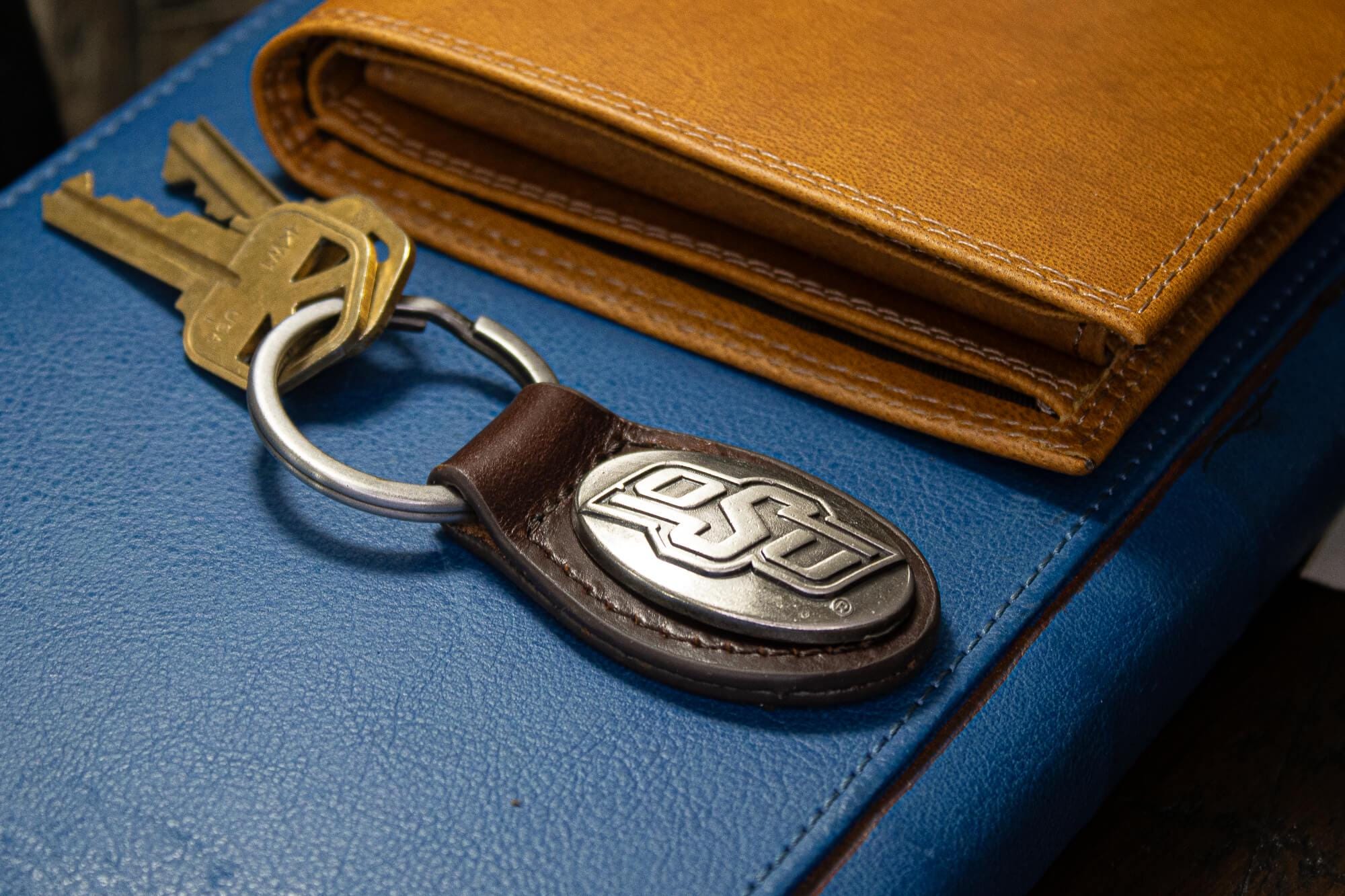 Oklahoma State Cowboys Oval Leather Key Fob. Split Ring and Durable Stitching. Perfect Collegiate Key Chain Gift. Brown or Black Leather.