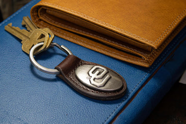 Oklahoma Sooners Oval Leather Key Fob. Sturdy Split Ring and Durable Stitching. Perfect Collegiate Key Chain Gift. Brown or Black Leather.