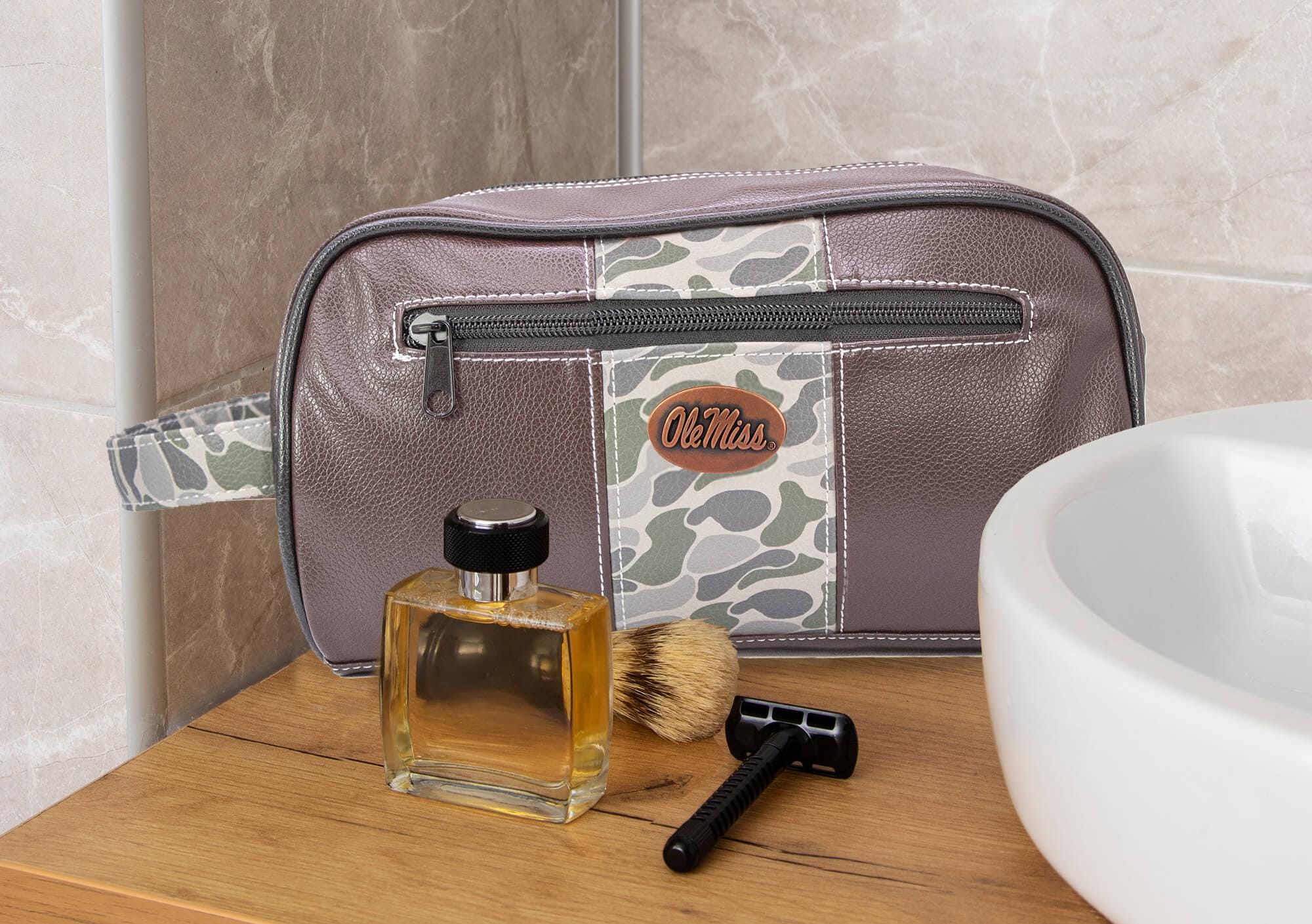 Ole Miss Rebels Men's Camo Dopp Kit. Toiletry Bag. Old School Camo Print. Brown Pebble Finish. Antique Copper Logo. Perfect Travel Accessory