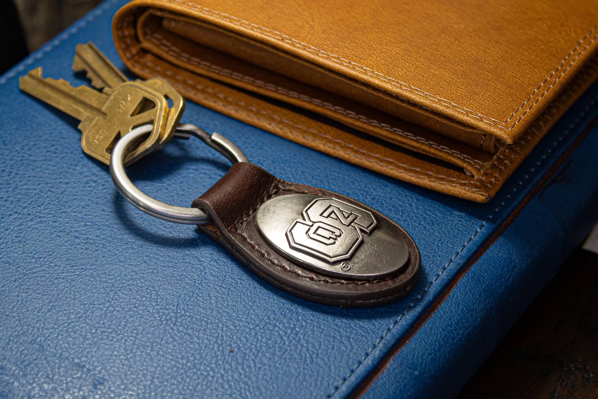 NC State Wolfpack Oval Leather Key Fob. Sturdy Split Ring and Durable Stitching. Perfect Collegiate Key Chain Gift. Brown or Black Leather.