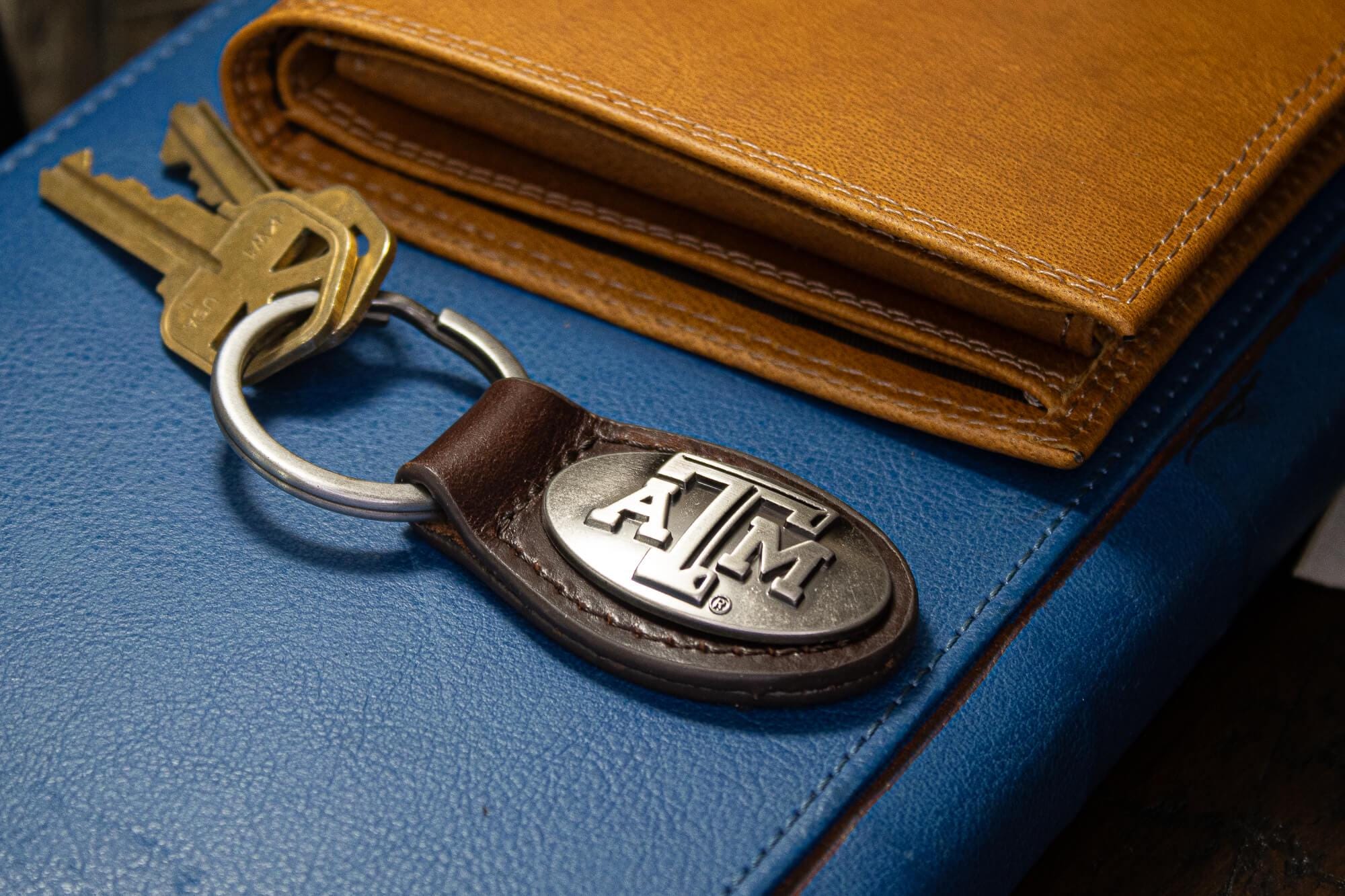 Texas A&M Aggies Oval Leather Key Fob. Sturdy Split Ring and Durable Stitching. Perfect Collegiate Key Chain Gift. Brown or Black Leather.